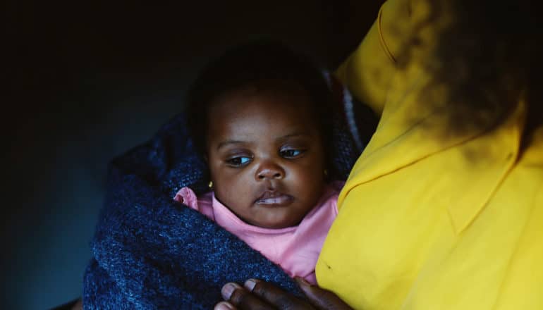 gloomy shot of adult holding baby in blanket