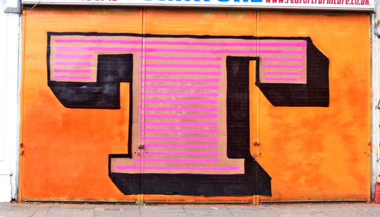 The letter T is painted on a store front shutter