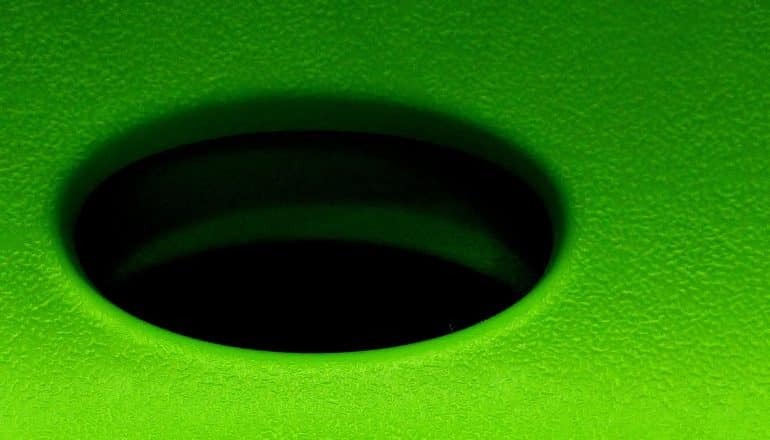 A black hole in a green plastic surface