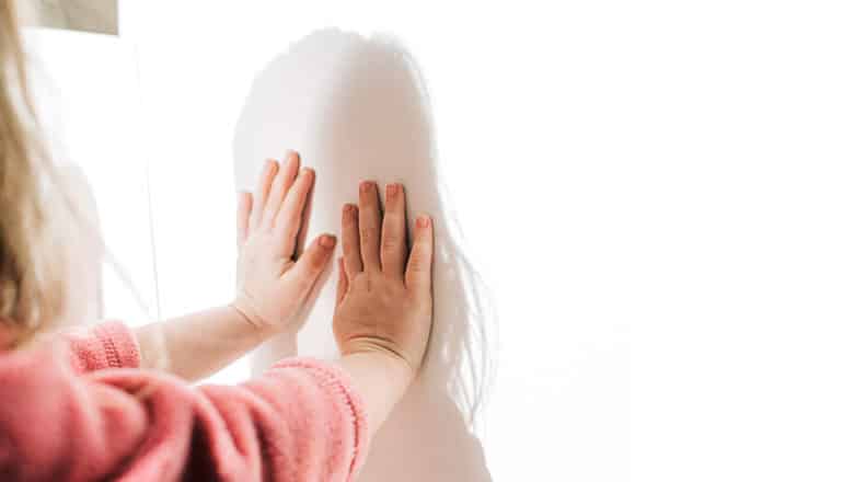 child's hands on shadow of their head