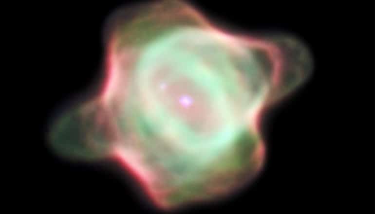 A photo of the stingray nebula from 1998, which shows up green and pink against the blackness of space