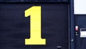 The number 1 painted on a black garage door