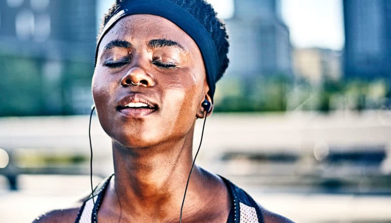 A woman closes her eyes while taking a break from exercise