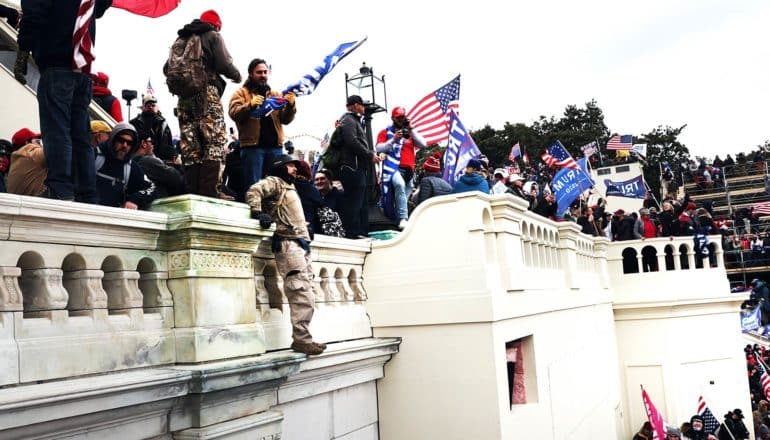 A violent mob attacks the Capitol while waving Trump flags