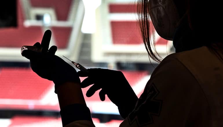 A health worker fills a syringe with the COVID-19 vaccine