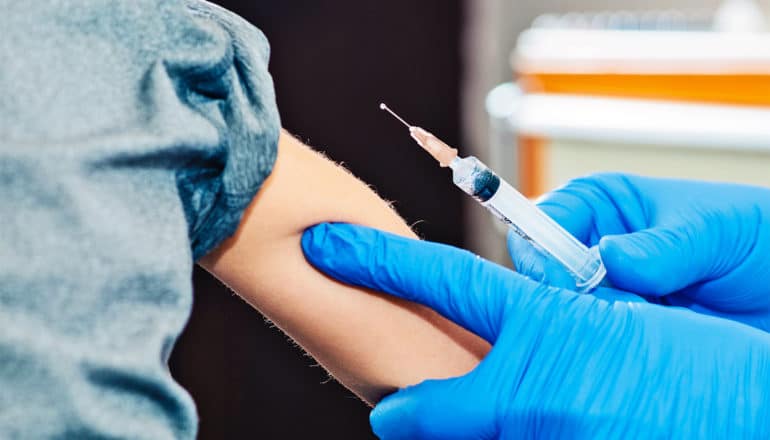 A doctor gives a child a flu shot