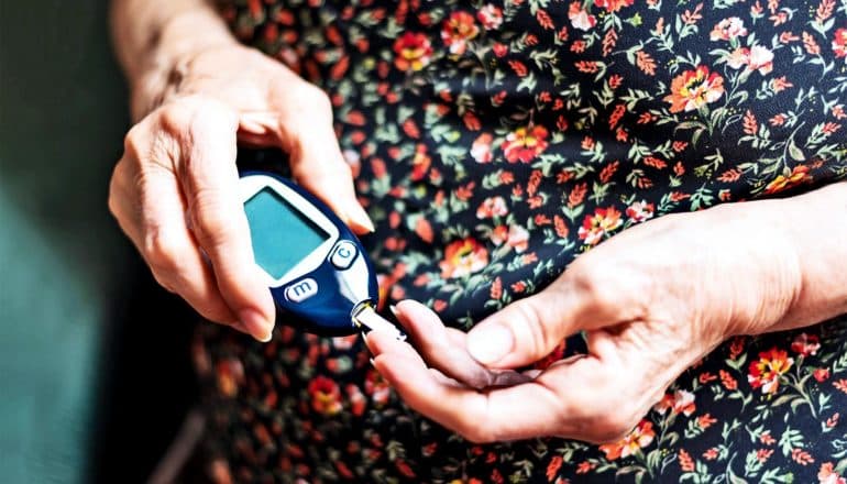 A woman holds a blood sugar test for diabetics