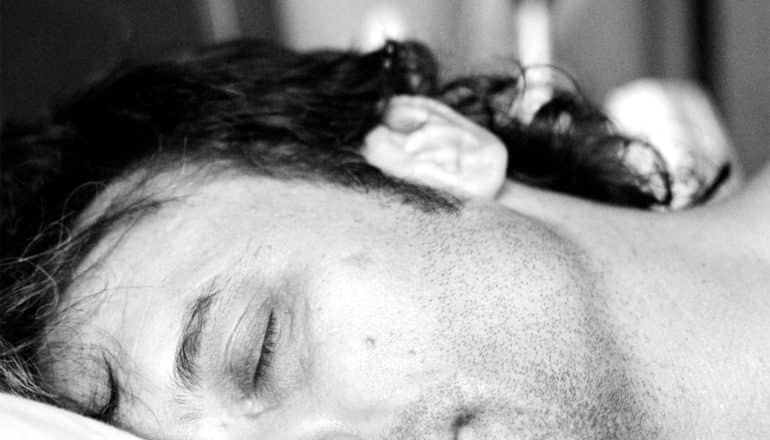 A man sleeping with half his face out of frame