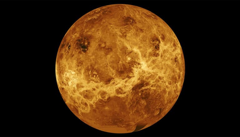 The planet Venus looks orange against a black background