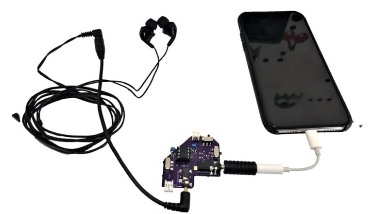 Headphones plugged into a chip connected to a smartphone