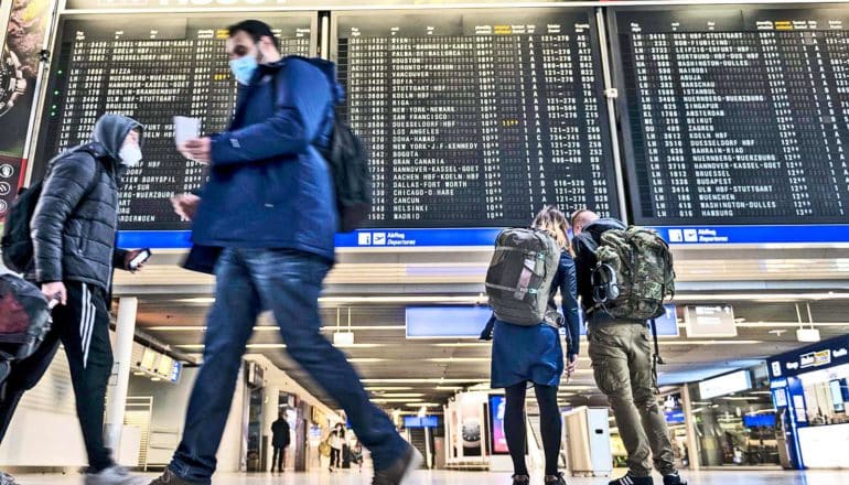 Travelers look up at the flight information in an airport