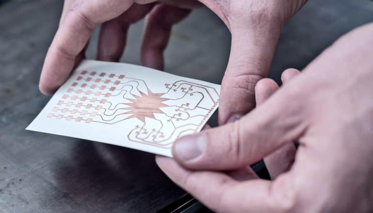 The prototype harvester is a small white card with gold-colored metal printed on its surface