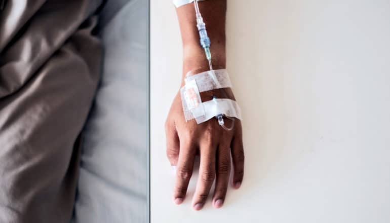 A man's hand and arm while getting a chemotherapy infusion