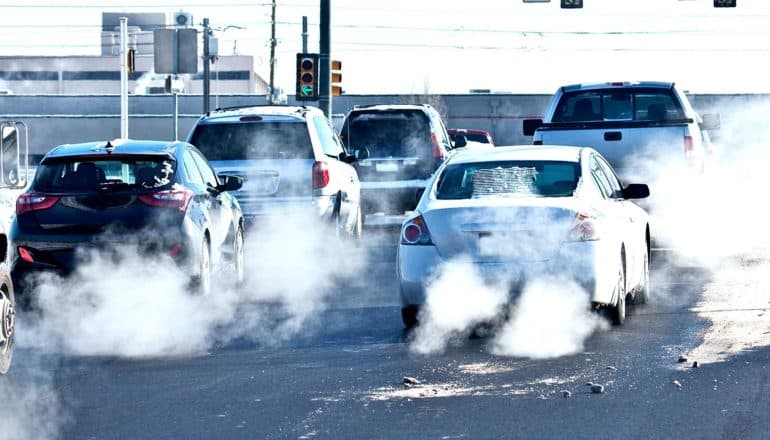 Cars at a stop light emitting exhaust