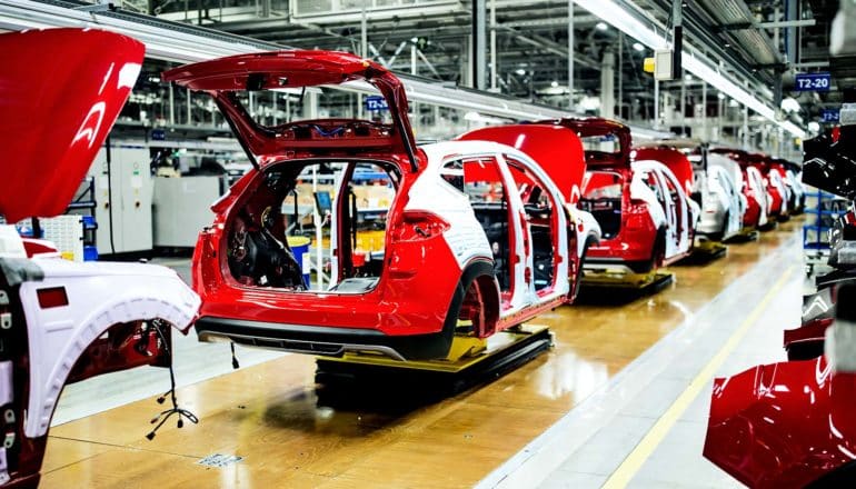 An assembly line of red cars in a row