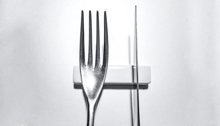 tops of fork and knife on stand in b/w