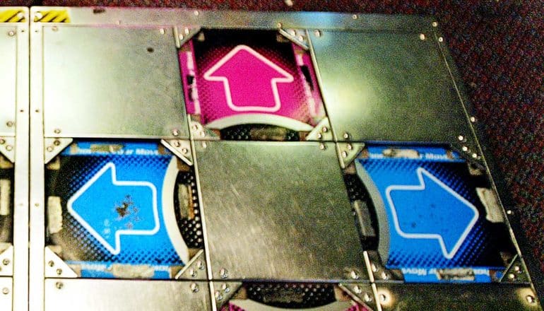 Blue and pink arrows on the floor of a dancing arcade machine