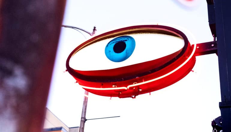 An eye-shaped sign with a red neon border