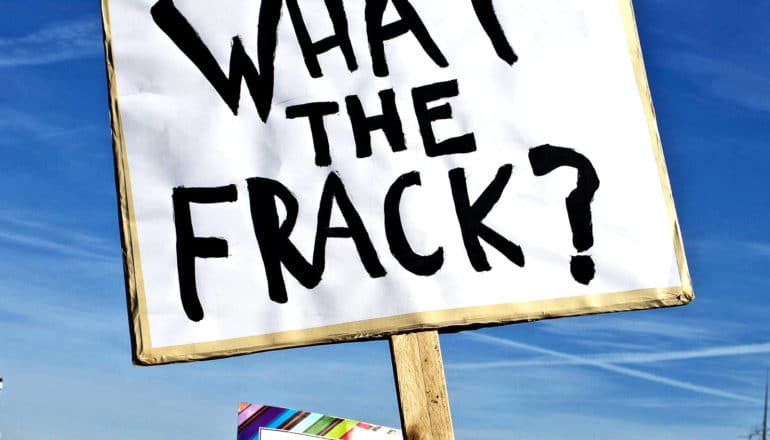 A protestor's sign reads "What the frack?"