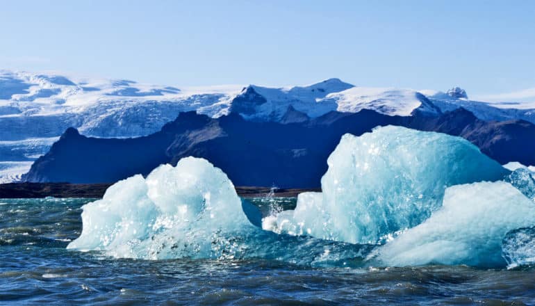 Glaciers in the ocean with mountains in the background