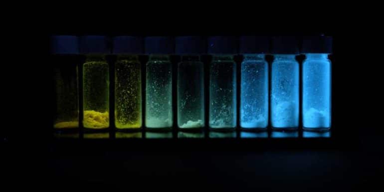 row of vials containing powder glow yellow, green, blue