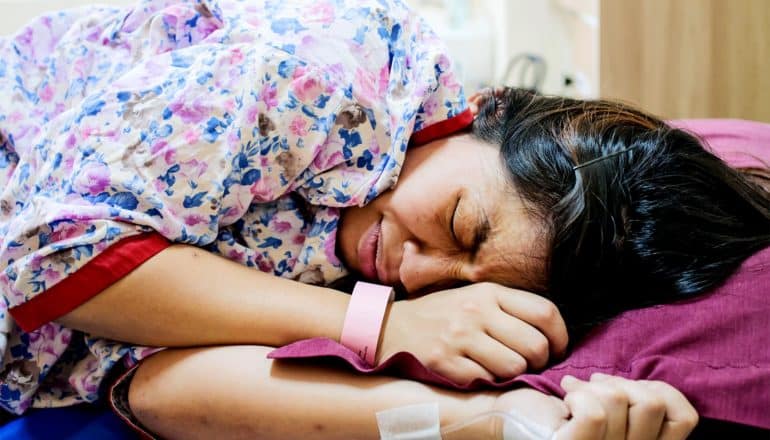 A woman preps to give birth with a grimace on her face