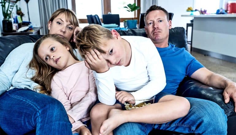 A bored family sits on the couch