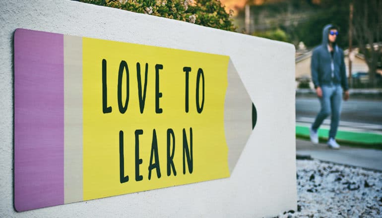 pencil-shaped sign says "love to learn"