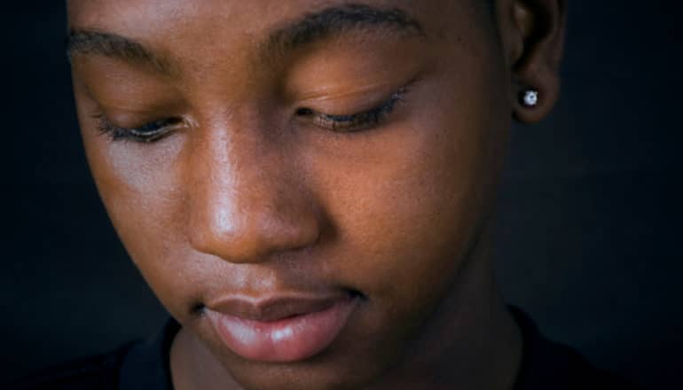 portrait: Black teen looks downward