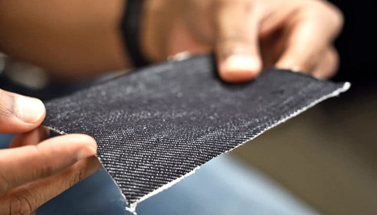 A researcher holds a piece of the black fabric