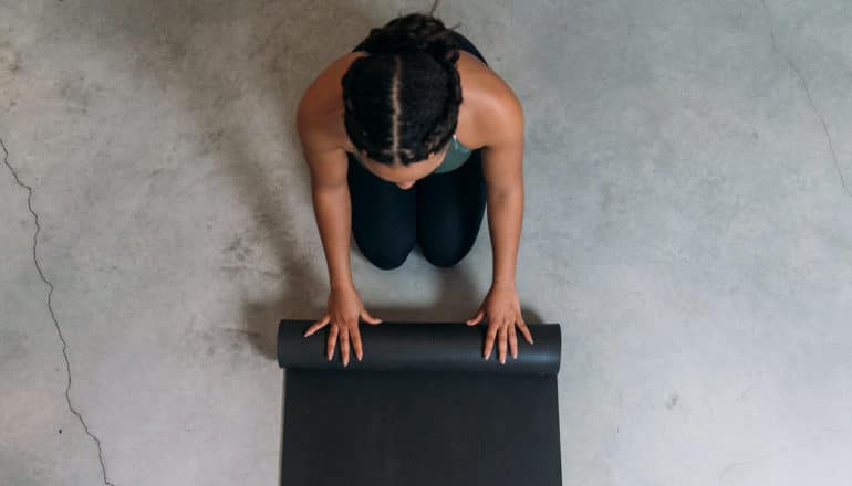 overheat shot of Black woman with yoga mat