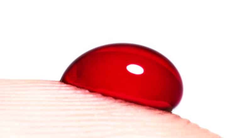 A drop of blood on a person's finger tip