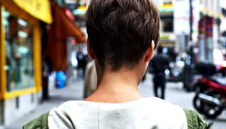 A person walking down the sidewalk shot from the neck up