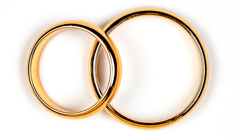 Two gold wedding rings on a white background