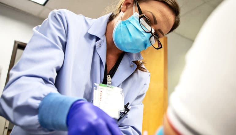 A doctor draws a patient's blood