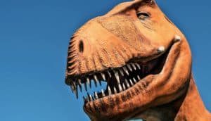 A statue of a t. rex with its mouth slightly open