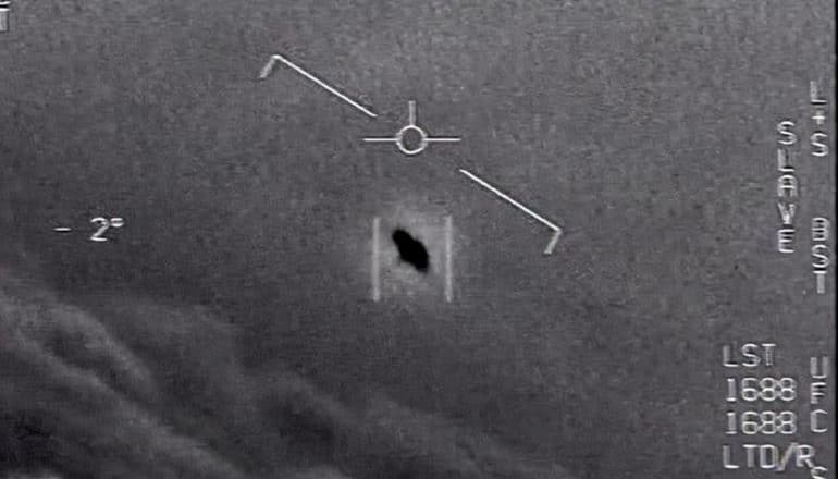 A video still shows a dark object in the sky