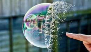 A person pops a bubble with their finger