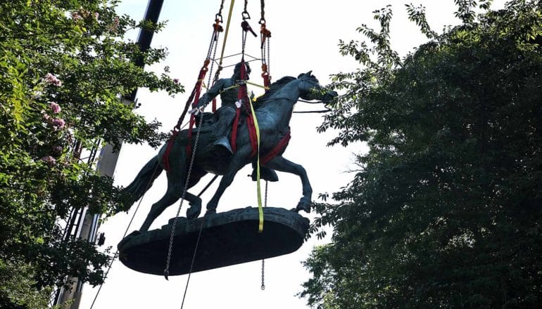 A monument depicting Stonewall Jackson on his horse is removed by crane