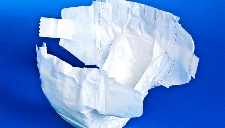 A white disposable diaper on a blue background