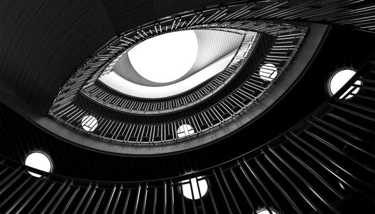 A spiral stairway looks like an eye shot from below in black and white