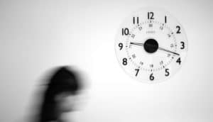 A person walks past a clock on the wall