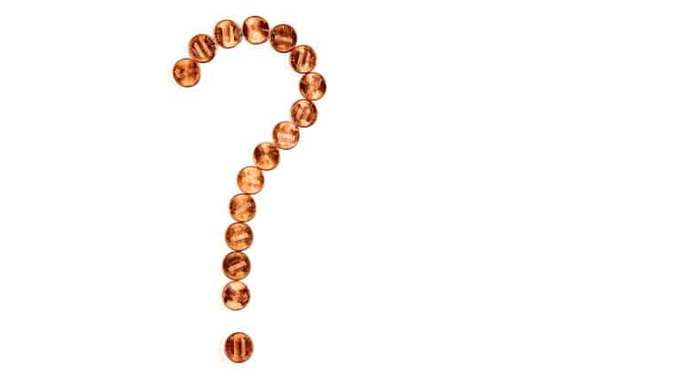 Pennies make the shape of a question mark on a white background