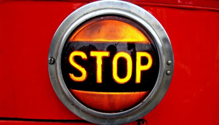 A light on red metal that reads "STOP"