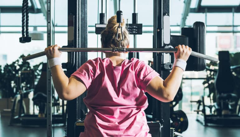 person uses weight machine in gym