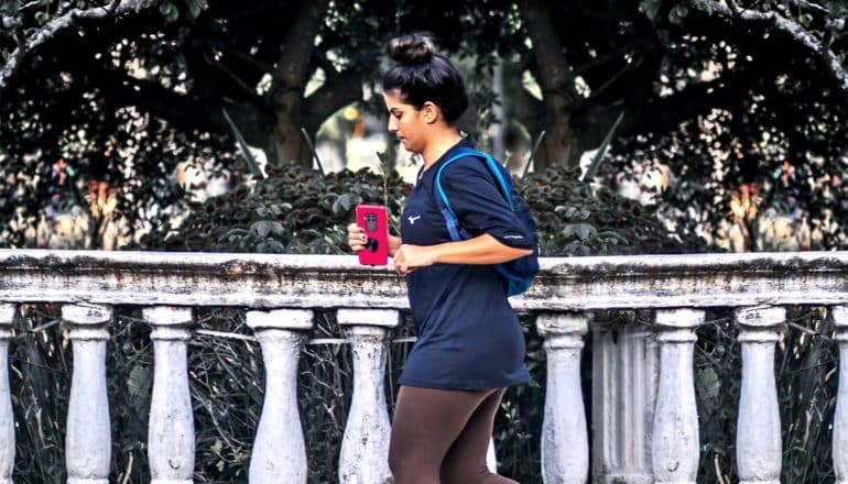 A woman runs next to a stone railing