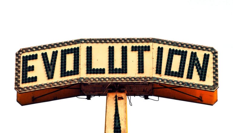 A sign with marquee lights reads "Evolution" against a white background