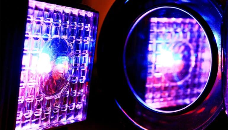 A pink, blue, and purple light reflected in a mirror