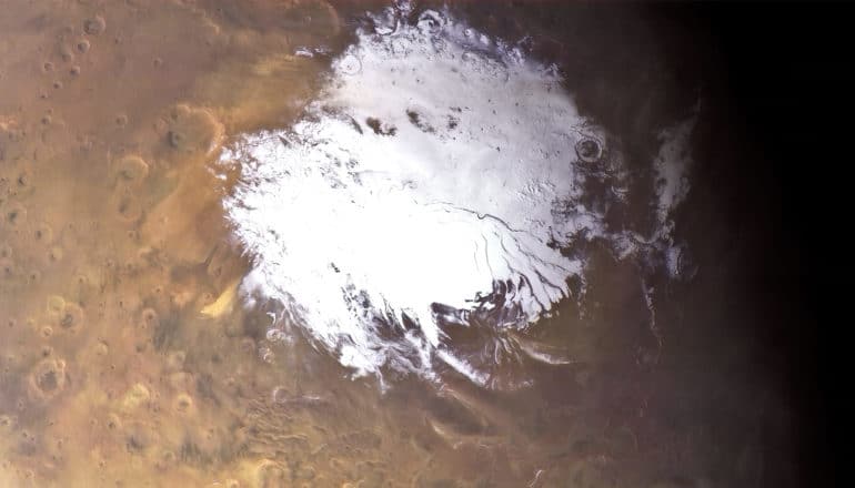 The southern ice cap on Mars is white against the red planet and blackness of space