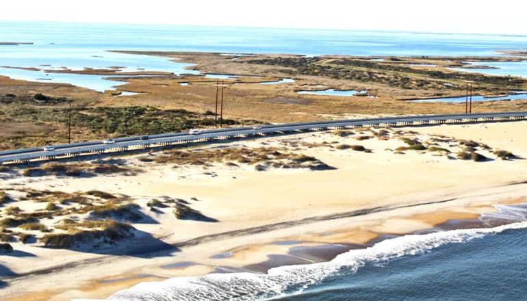 A barrier island with a highway running across it with the ocean on either side